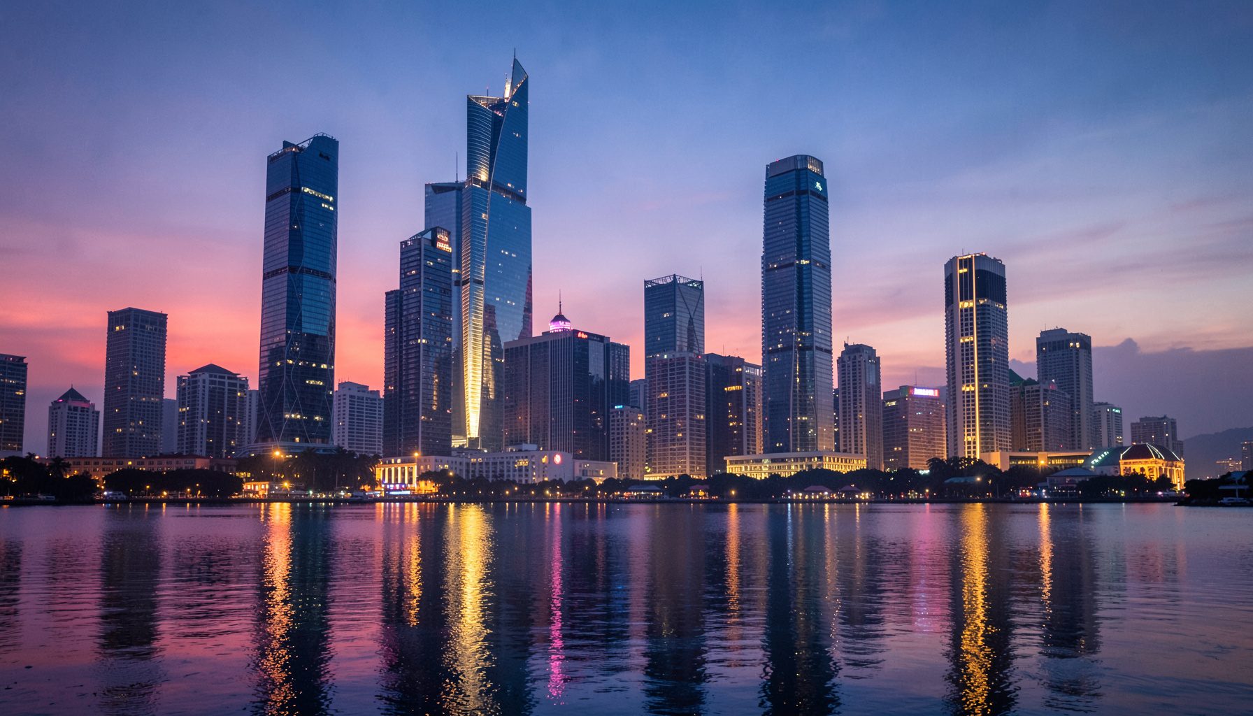 Skyline moderne d'une métropole asiatique au crépuscule, gratte-ciel illuminés se reflétant sur l'eau, tons bleus et dorés
